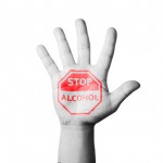 Hand zeigt Schild mit Stop Alkohol
